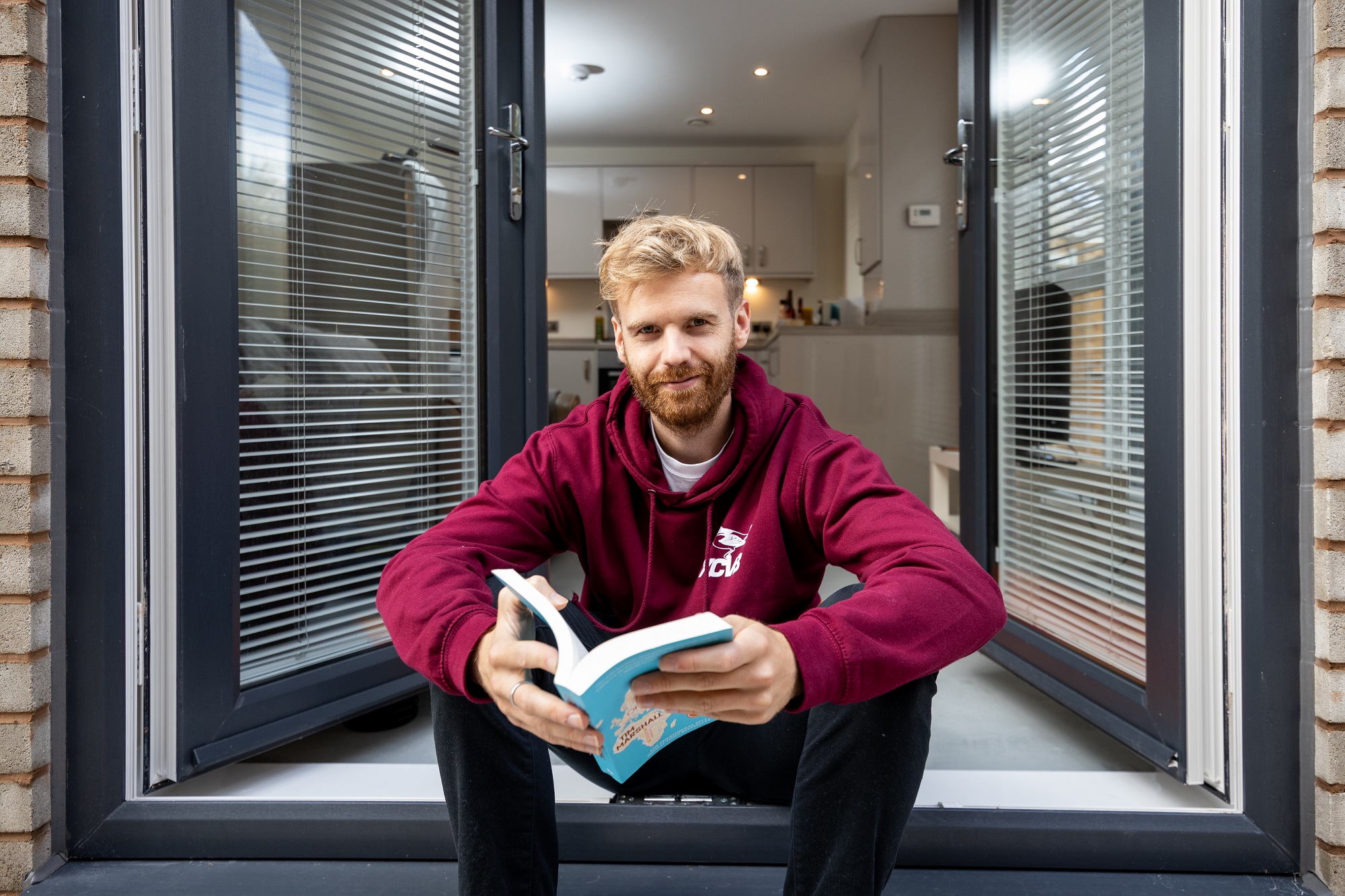 Chris sits on the patio at his shared ownership home in Liverpool