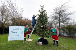 Woodlands head teacher hangs a bauble on the tree supplied by Onward Living